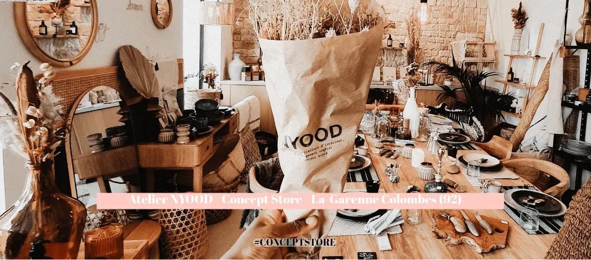 Intérieur du concept store Atelier Nyood à La Garenne-Colombes, mobilier en bois, fleurs séchées et vaisselle.