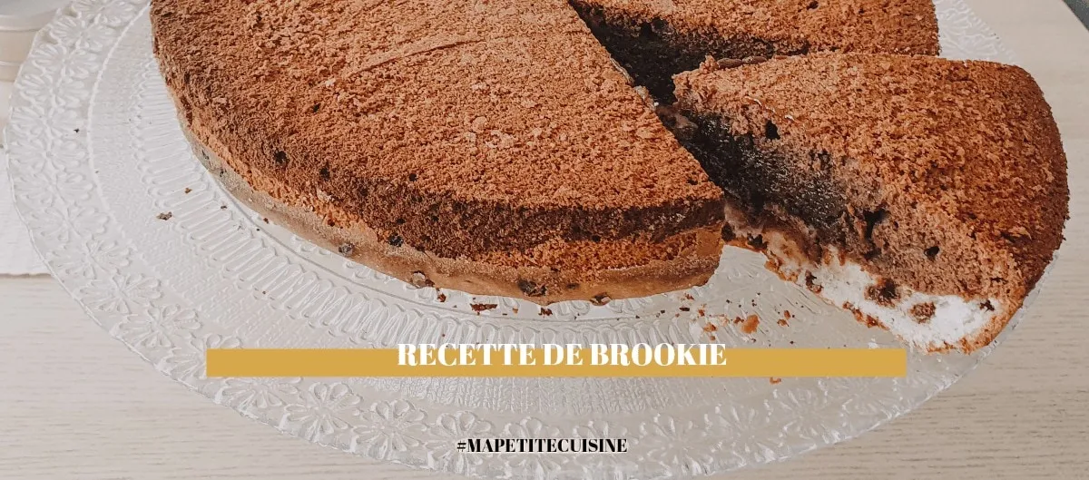 Brookie maison saupoudré de cacao sur un plat en verre, une part découpée