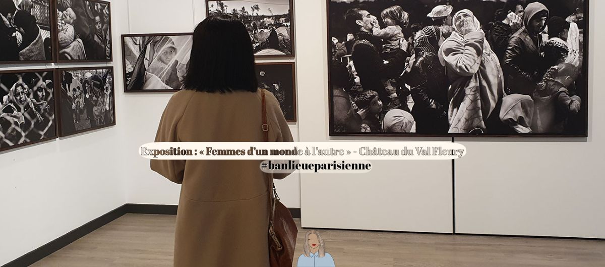 Femme en manteau beige observant des photographies en noir et blanc lors d'une exposition en galerie
