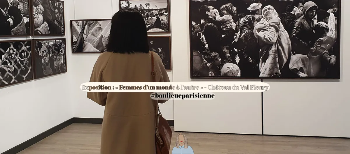 Femme en manteau beige observant des photographies en noir et blanc lors d'une exposition en galerie