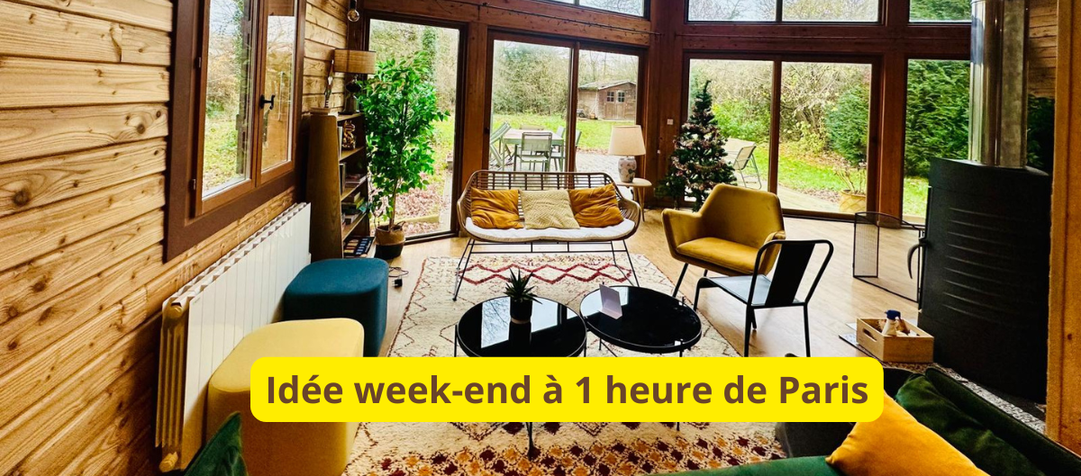 Salon chaleureux d'un chalet en bois avec de grandes baies vitrées donnant sur un jardin
