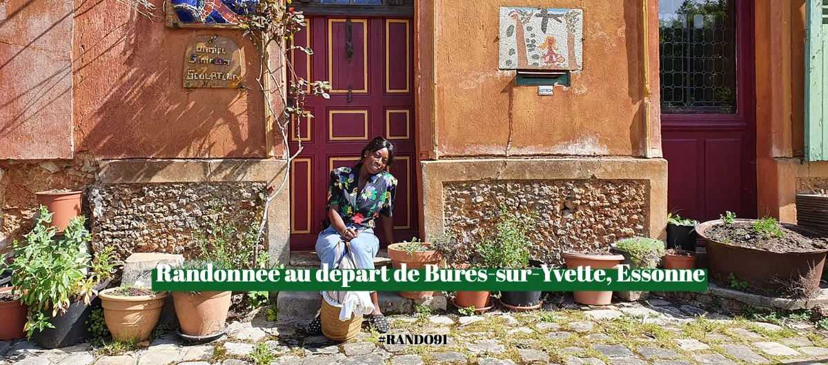 Randonneuse assise devant une maison ancienne fleurie à Bures-sur-Yvette, en Essonne