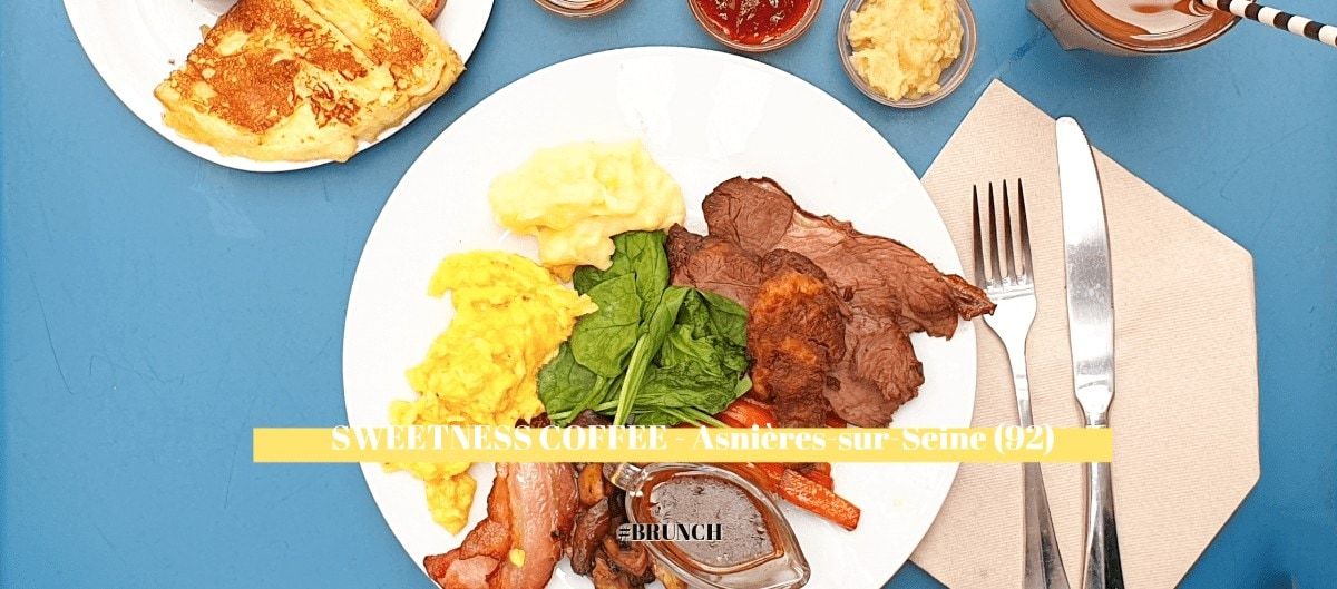 Assiette de brunch garnie d'œufs brouillés, pain perdu, viande rôtie et épinards sur une table bleue