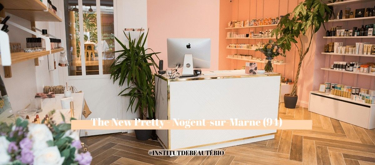 Intérieur d'un institut de beauté avec comptoir blanc, plantes vertes et étagères de cosmétiques
