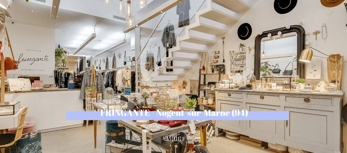 Intérieur de la boutique Fringante à Nogent-sur-Marne : vêtements, bijoux et objets déco autour d'un escalier blanc.