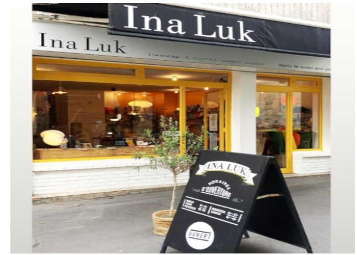 Devanture de la boutique Ina Luk à Montreuil, avec ses vitrines à cadres jaunes et son olivier en pot