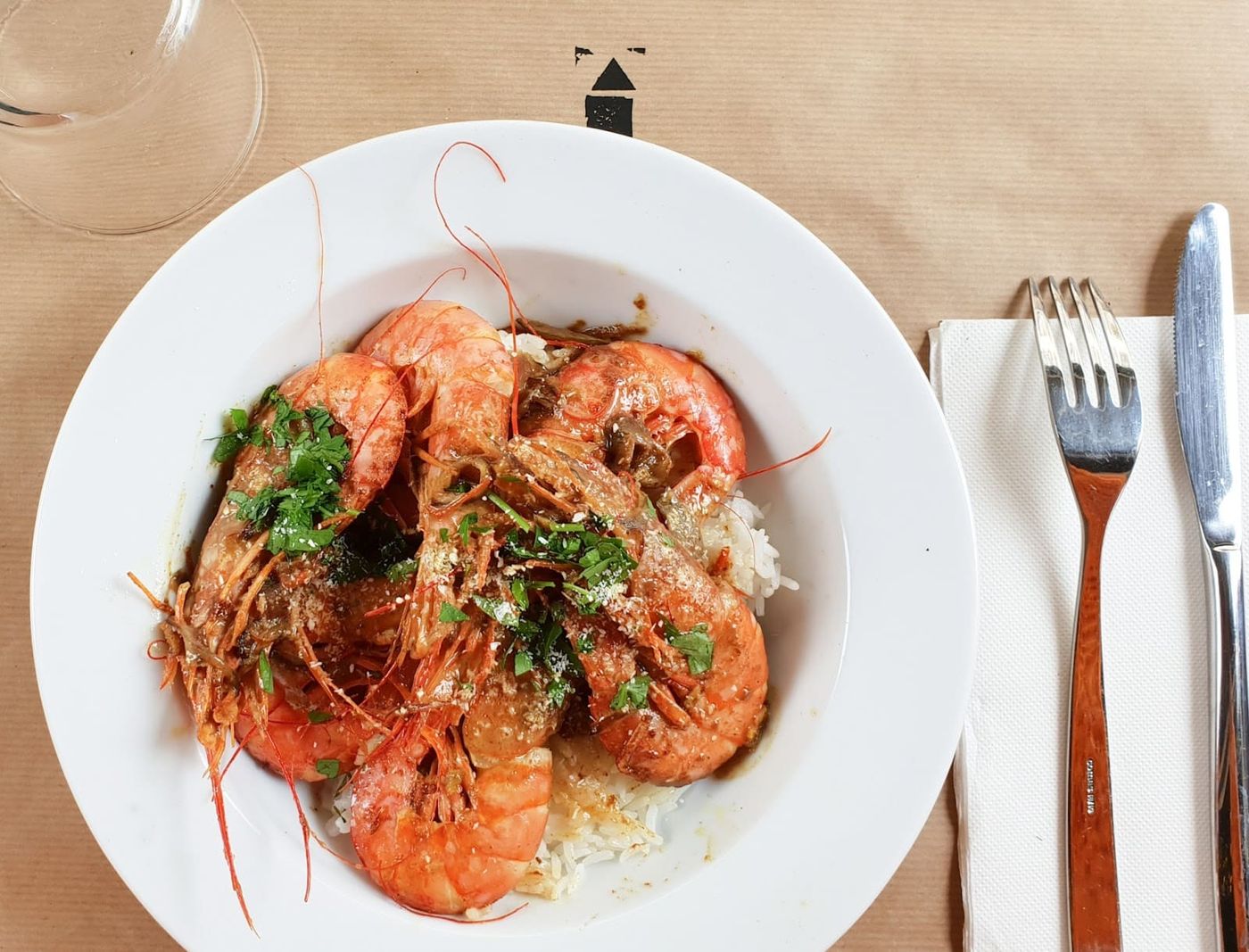 Assiette de gambas sur du riz aux herbes fraîches, servie au restaurant La Maison à Montreuil.