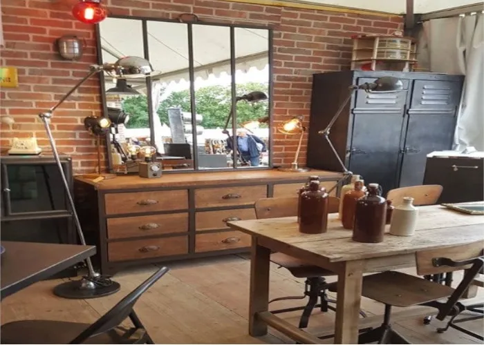 Intérieur de la boutique O'range Métalic à Bièvres, mobilier de style industriel et mur de briques.