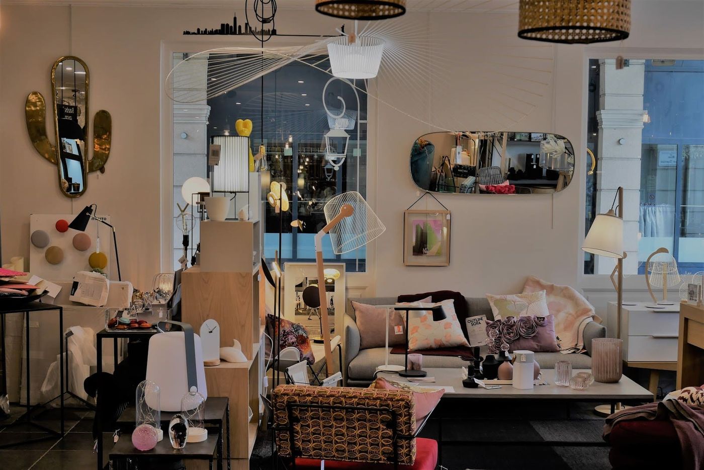 Intérieur de la boutique de décoration Une Place en Ville avec luminaires, miroirs et mobilier