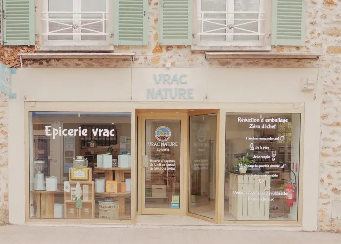 Façade de l'épicerie vrac Vrac Nature avec ses volets verts et sa vitrine